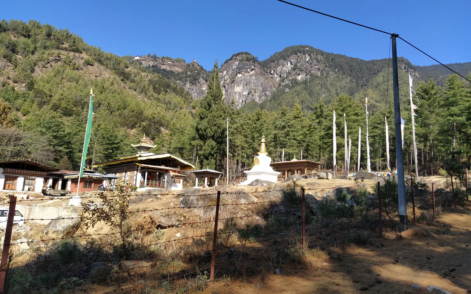 A Bhutanese dzong-style temple and white stupa set in a mountain valley — original photo by goFLY founder Mahabub Alam Razu, Bhutan, December 2019