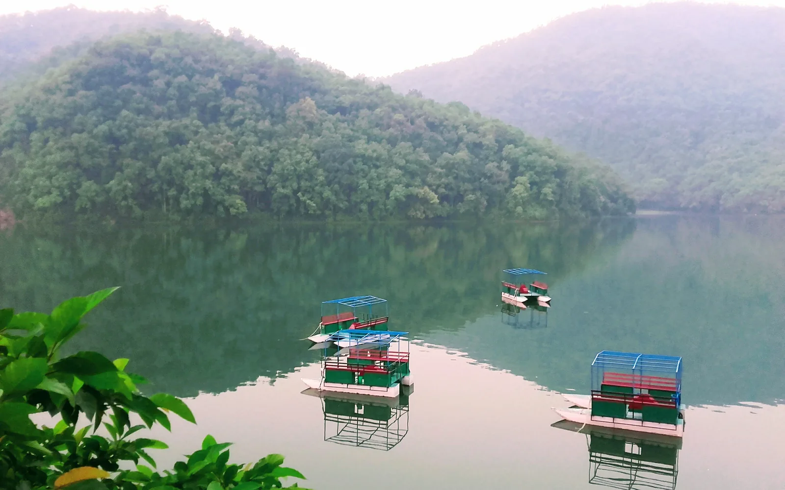 Phewa Lake framed by forested hills near Pokhara with small boats on the water — photo by goFLY founder Mahabub Alam Razu, May 2017