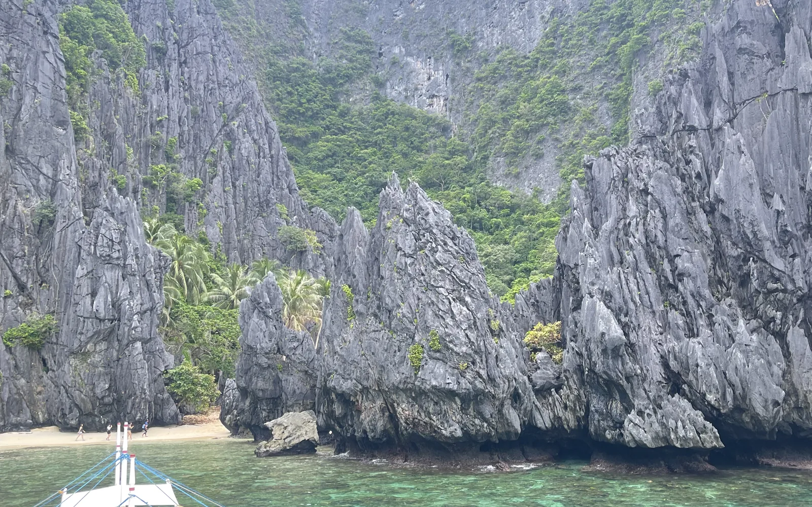An outrigger boat moored in a lagoon ringed by limestone cliffs, El Nido, Palawan, Philippines — photo by goFLY founder Mahabub Alam Razu, August 2024