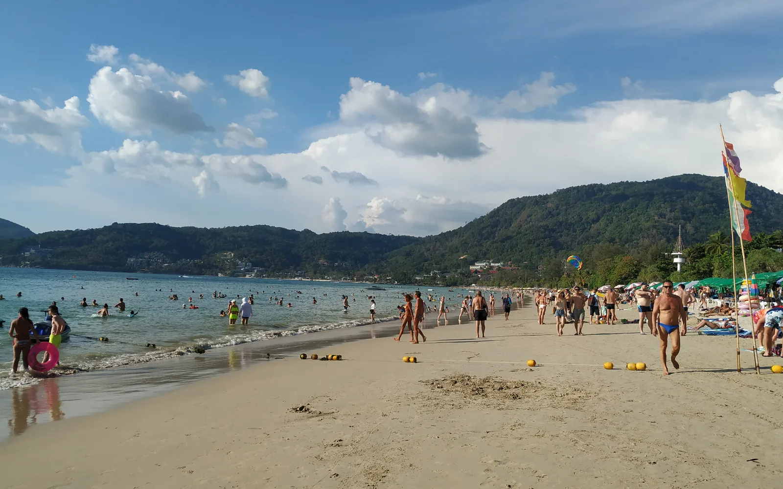 Sunbathers and green headlands along Patong Beach, Phuket, Thailand — photo by goFLY founder Mahabub Alam Razu, March 2019